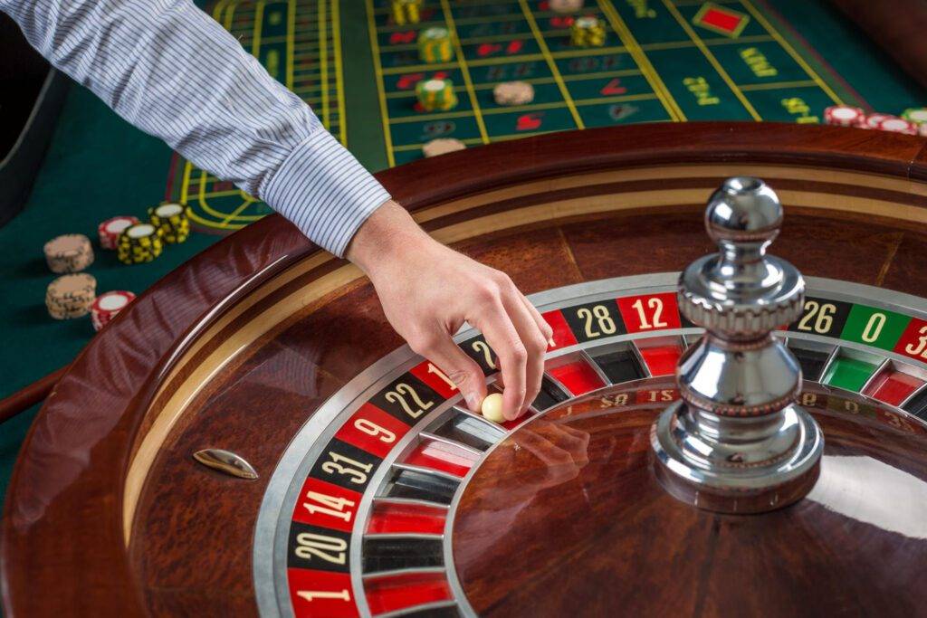 roulette-wheel-croupier-hand-with-white-ball-casino-close-up-details